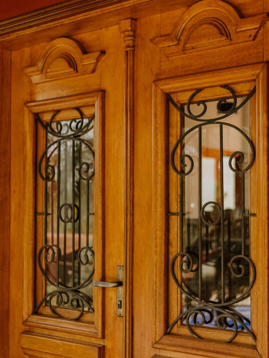Porta dupla de madeira maciça com detalhes em vidro